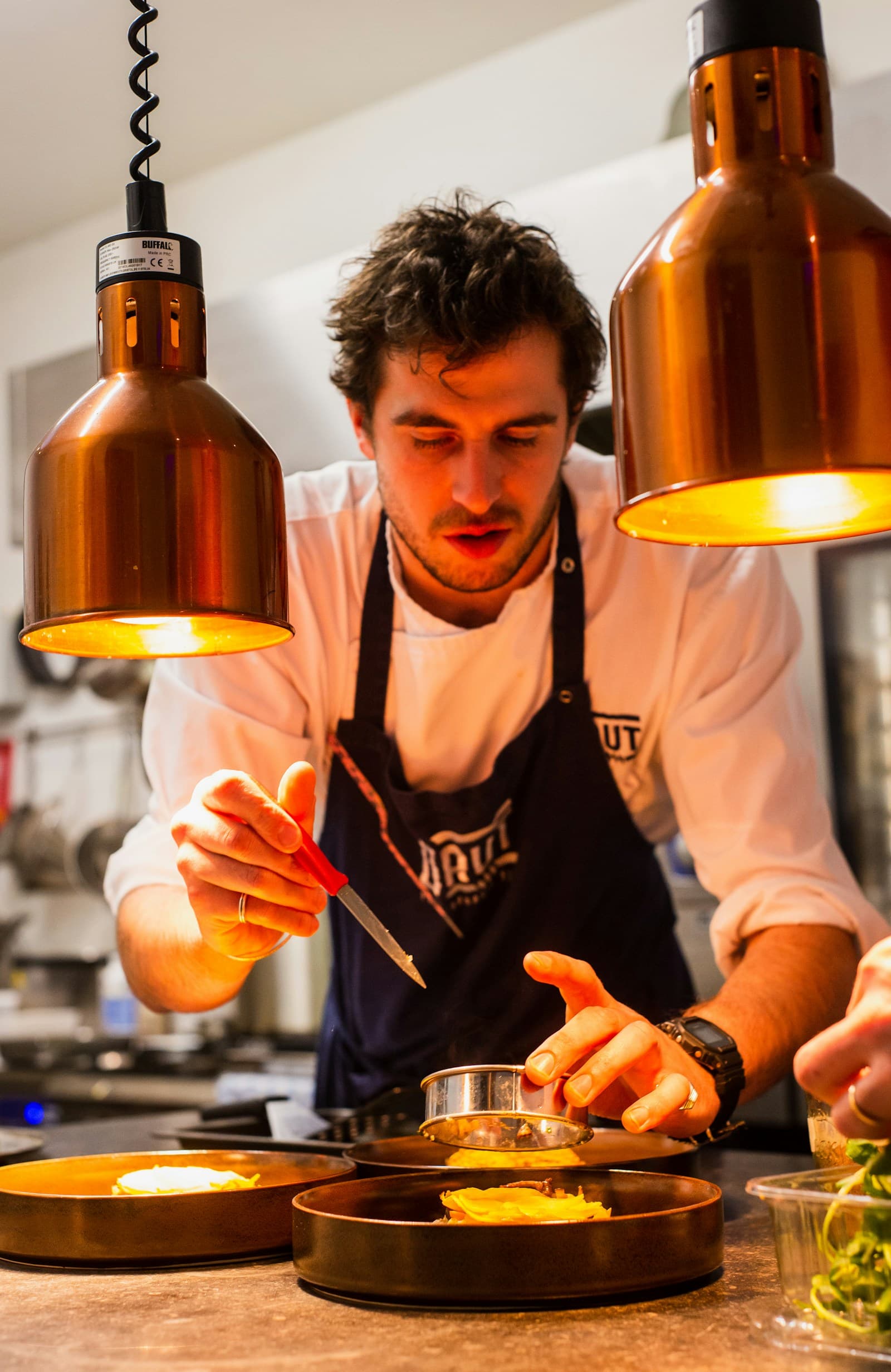 Chef carefully finishing a dish in the restaurant kitchen
